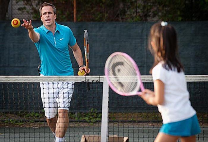 Tennis instructor giving a child a private one-on-one lesson at Rushcutters Bay Park Tennis